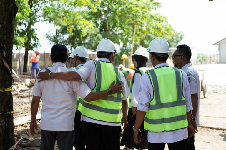 Trabajadores con cascos y chalecos reunidos en una charla de seguridad