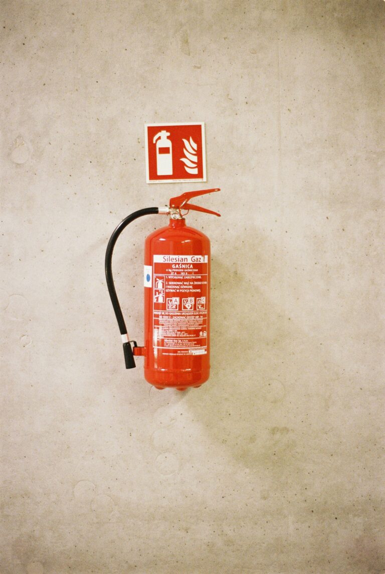 Extintor rojo montado en una pared de hormigón