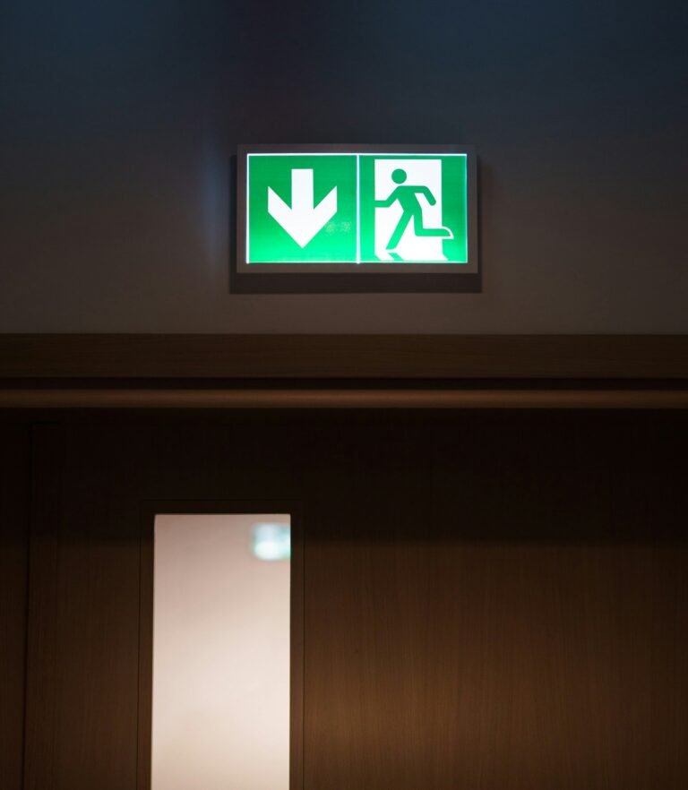Cartel verde de salida de emergencia sobre una puerta